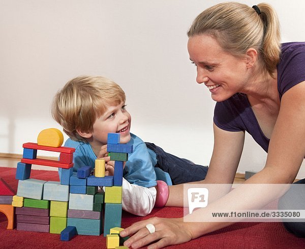 Mutter und Sohn spielen mit Bausteinen