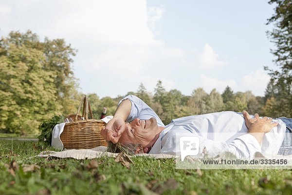 Mann liegt entspannt auf einer Decke