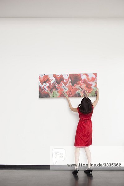 woman hanging up a picture