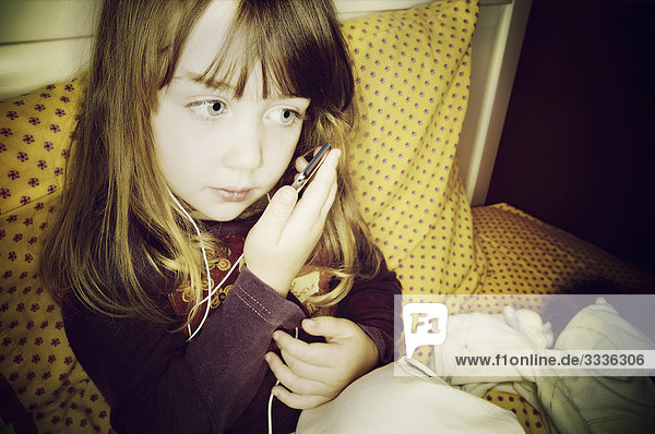 Kleines Mädchen sitzen auf dem Bett hören auf iPod  Otterburn Park  Québec