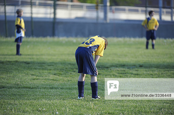 Young boy with head down  in soccer match