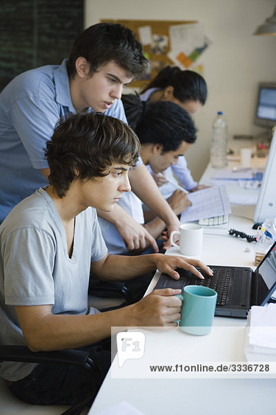 Male college students working together using laptop computer
