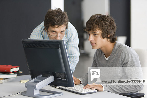Teacher assisting student with computer assignment