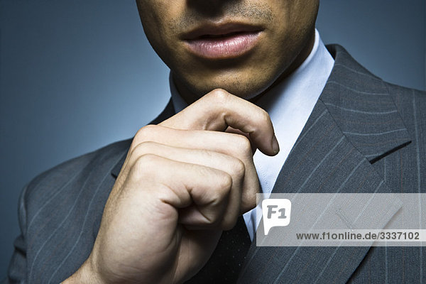 Businessman with hand under chin  cropped portrait