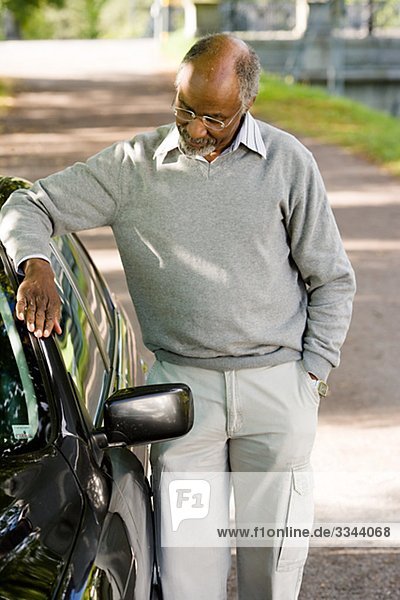 Senior man standing by a black car  Sweden.