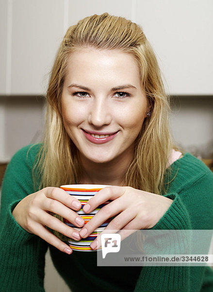 A blond young woman having a cup of coffee  Sweden.