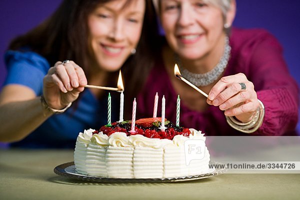 Two women with a birthday cake.