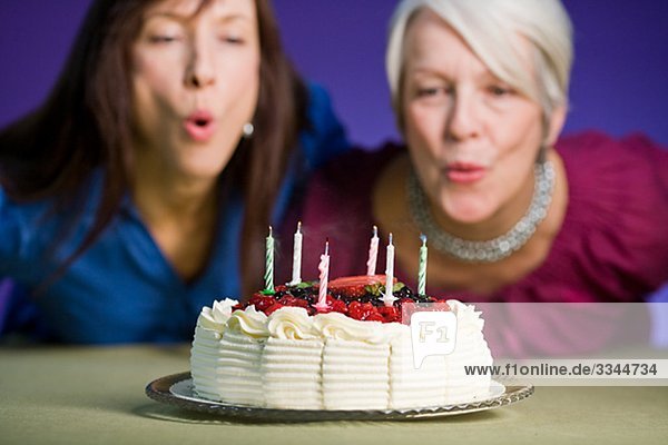 Zwei Frauen mit einem Geburtstagskuchen.