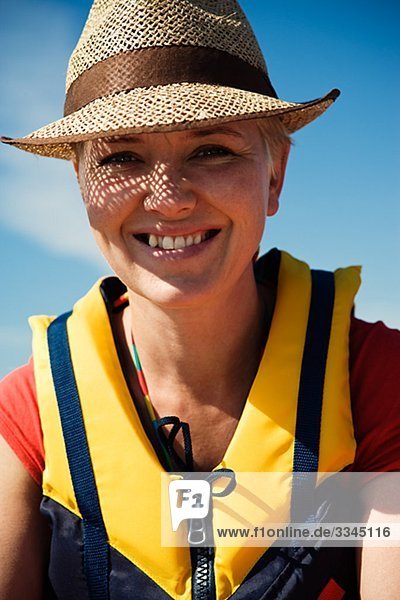 Frau trägt eine Schwimmweste und einem Strohhut Schweden.