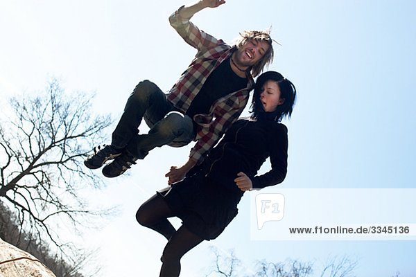 A young couple jumping up in the air,  Sweden.