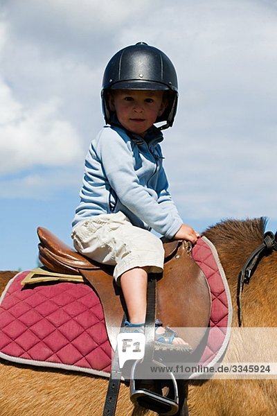 Portrait von einem kleinen Jungen auf einem Pferd  Schweden.
