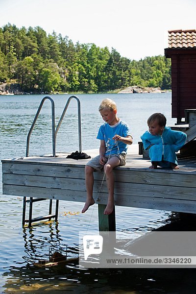 Two boys on a jetty  Stovkholm archipelago  Sweden.