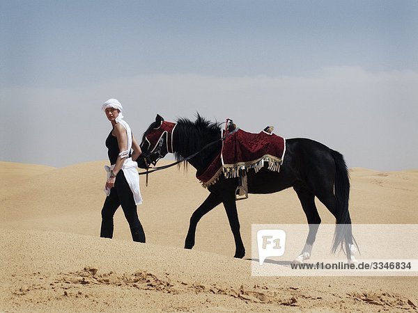 Frau mit einem Pferd in der Wüste  Tunesien.