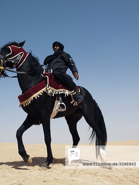 Beduinen auf ein schwarzes Pferd gegen einen blauen Himmel  Tunesien.