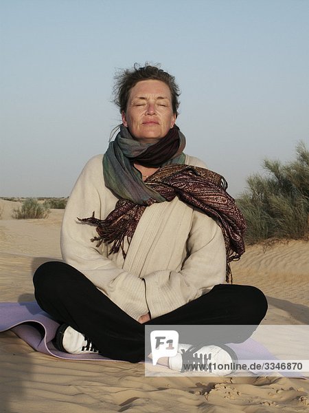 Frau meditierend in der Wüste  Tunesien.