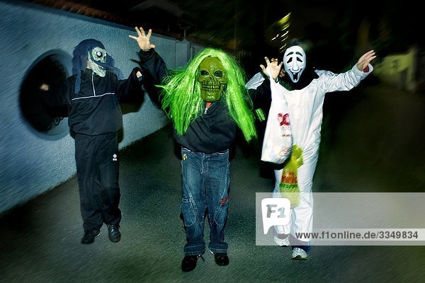 three people dressed up for Halloween walking on the street