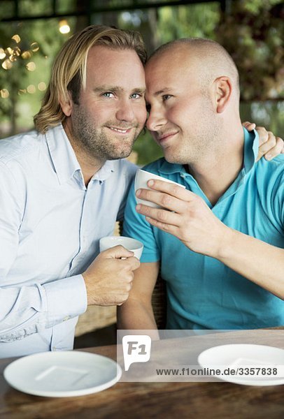 Zwei schwule Männer beim Kuscheln im Kaffeehaus