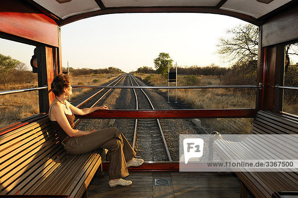 Rovos Rail  Private Zug  aus Pretoria nach Victoria-Fälle  Gauteng  Südafrika  Eisenbahn  Eisenbahn  Luxus  Travel  Reisen  Reisen  Nostalgie  PKW  öffnen Sie Trainer  Passagier  Frau  Person  Sitzbank  tracks