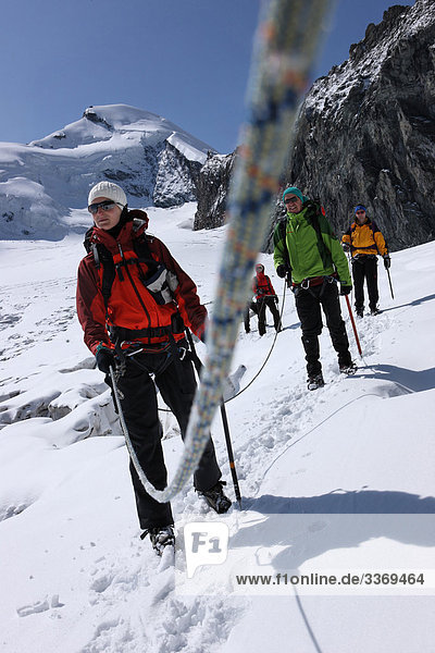 10870385  Winter  mountaineering  group  rope  glacier  ice  moraine  mountain  mountains  walking  hiking  canton Valais  Hohlaubgletscher  Allalinhorn  Alps  near Saas Fee  Switzerland  persons