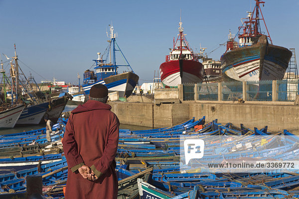 10871493  man  male  local  typical  dress  jellaba  fishing harbour  harbour  harbor  fishing boats  boats  Essaouira  Morocco  city  Moroccan  Muslim  North Africa  Africa  horizontal