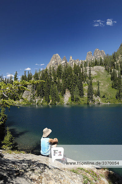Frau sitzt auf Stein über Blue Lake  North Cascades National Parks  Washington  USA