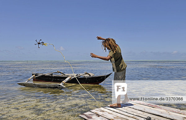 Afrika  Tanzania  Tansania  Zanzibar  Sansibar  Ostküste  Bwejuu  Auslegerboot  Boot  verankern  Mann  Mann