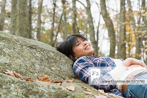 Young woman lying on stone