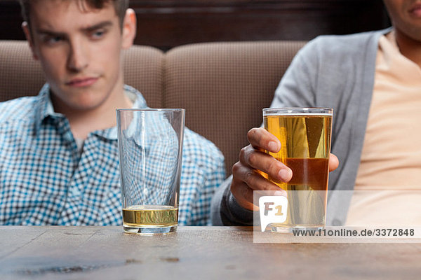 Junge Männer in der Bar mit Bier