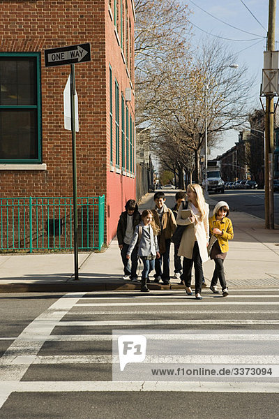 Lehrer und Schüler beim Überqueren der Straße
