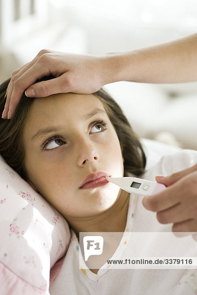 Mother checking daughter's temperature  caressing forehead  cropped