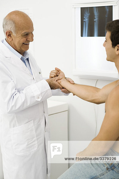Arzt untersucht das Handgelenk des Patienten