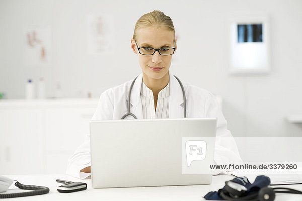 Ärztin mit Laptop am Schreibtisch
