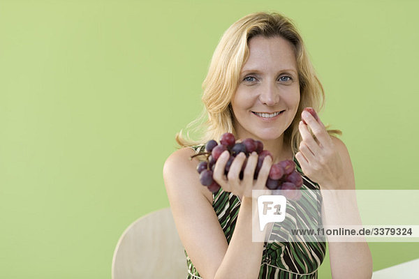 Mature woman eating grapes