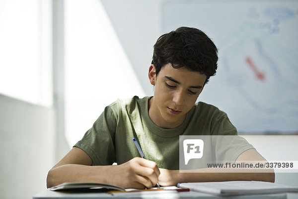 Teenager-Junge  der sich auf die Klassenarbeit konzentriert.