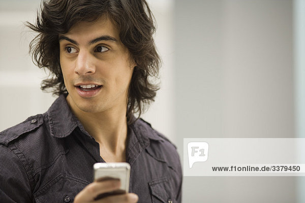 Young man text messaging  looking away in distraction