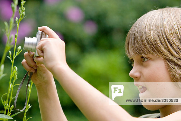 Junge fotografiert Blume