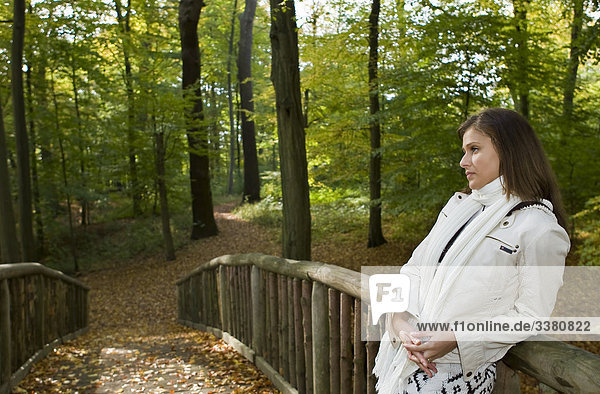 Juge Frau steht auf Brücke im Wald