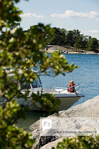 Motorboat berthing at a rock in the Stockholm archipelago  Sweden.
