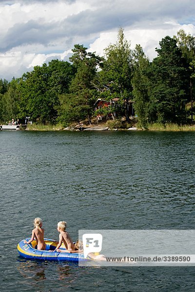 Drei Kinder in einem Schlauchboot  Schweden.