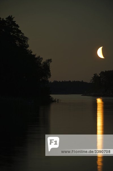 Ein Mond spiegelt sich auf der Oberfläche des Wassers  Schweden.