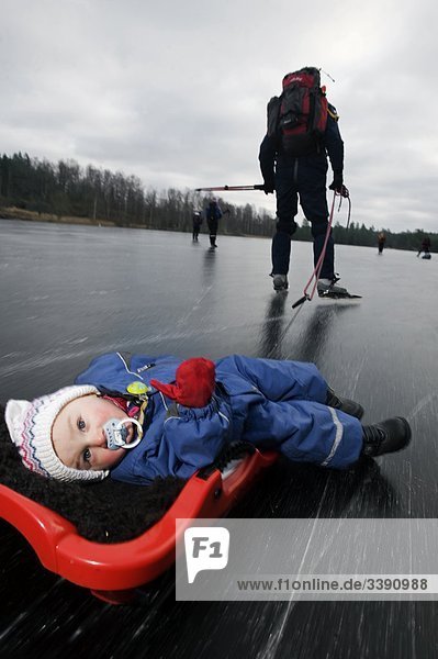 Mann mit einem Kind in ein wenig Schlitten  Schweden.