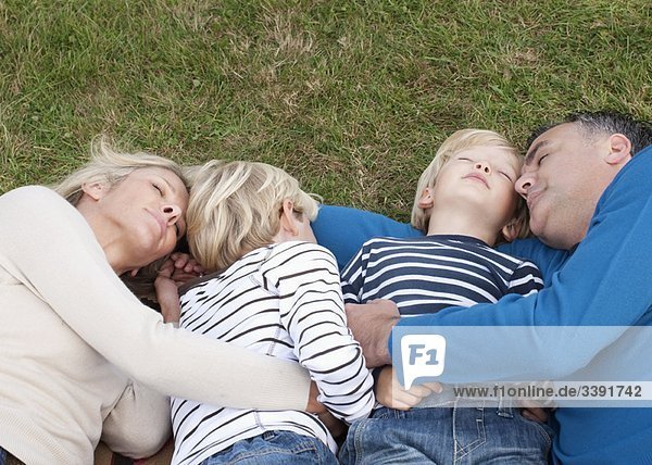 Family lying down together on grass