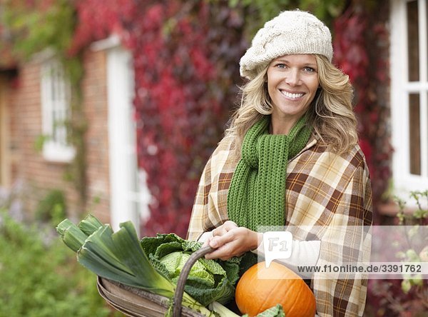 Smiling woman with seasonal vegetables