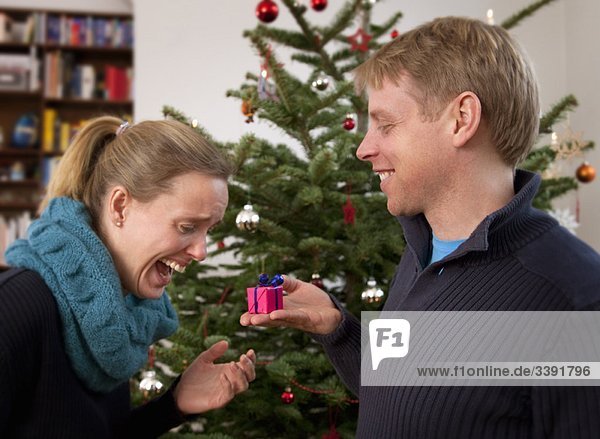 Mann schenkt Frau kleines Weihnachtsgeschenk
