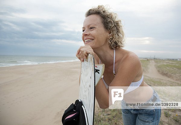 Frau mit Drachenbrett  mit Blick auf den Strand