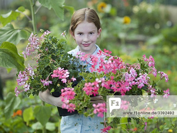 Ein junges Mädchen mit blühenden Topfpflanzen