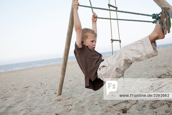 Boy on a swing at the beach