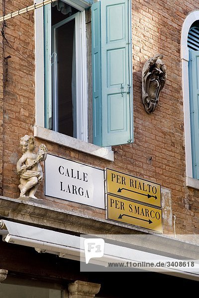 Straßenschild und Wegweiser an einer Hausfassade  Venedig  Italien  Flachwinkelansicht Hausfassade