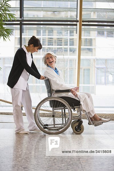 Alte Frau im Rollstuhl und Krankenschwester