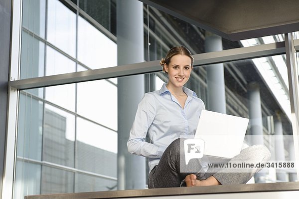 Junge Geschäftsfrau arbeitet mit Laptop